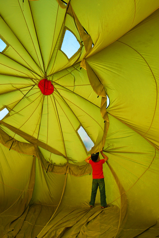 Little boy looks through hole of hot air balloon