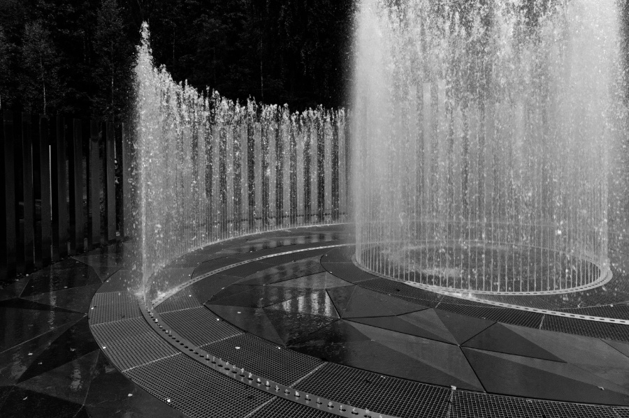 Circular fountains on an overcast day, in low key black and white