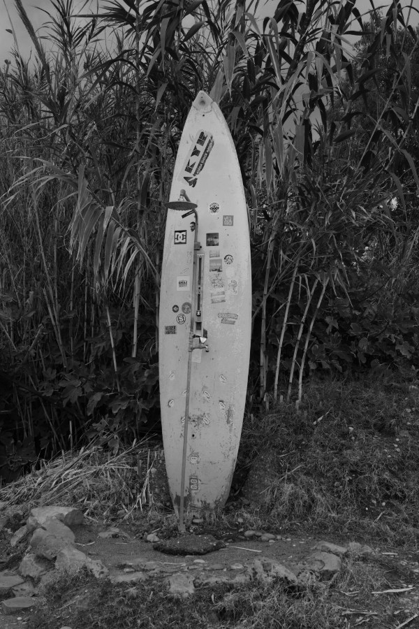 Surfboard and beach shower off season in black and white