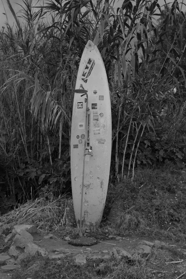 Surfboard and beach shower off season in black and white