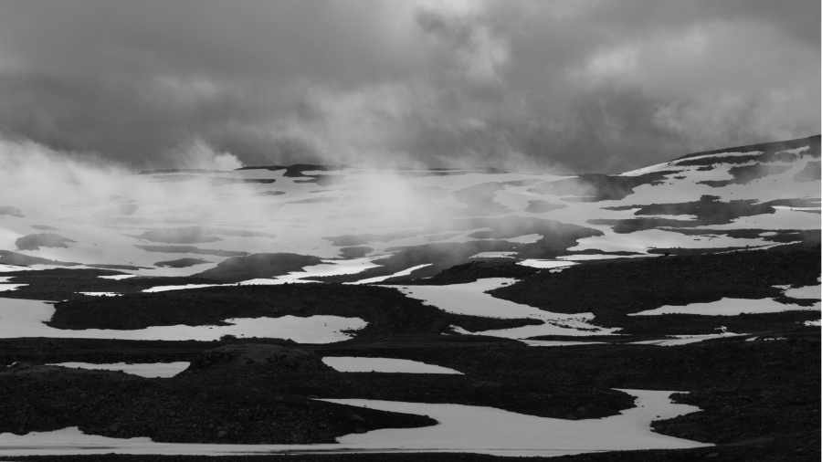 Seydisfjordur pass covered with snow under dark clouds, black and white